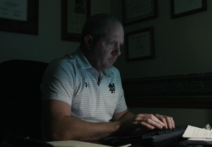 Attorney Paul Farrell Jr. sitting in a dark room and typing on a keyboard.